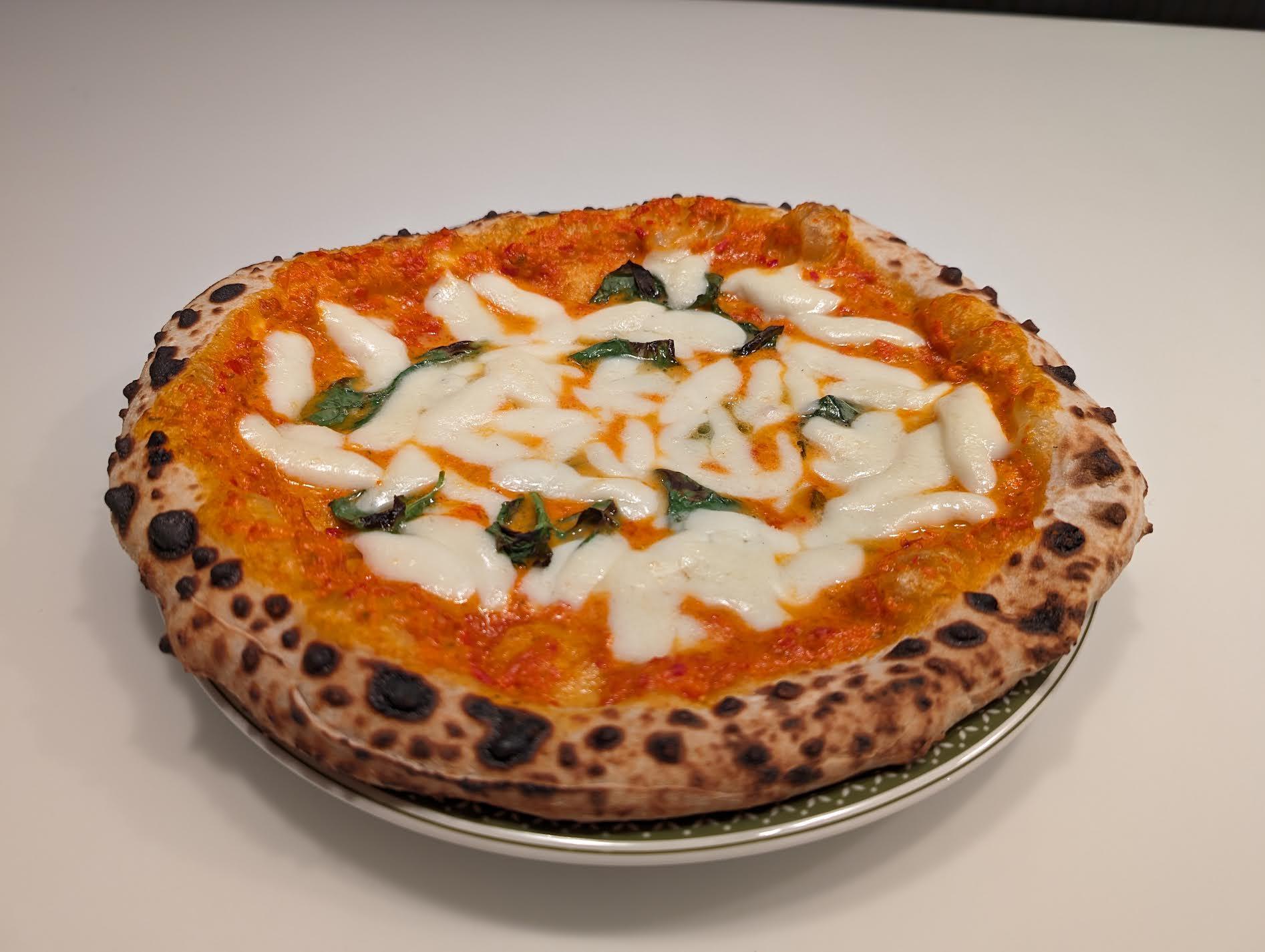 Neapolitan pizza with a leopard-spotted cornicione fresh from a wood-fired oven